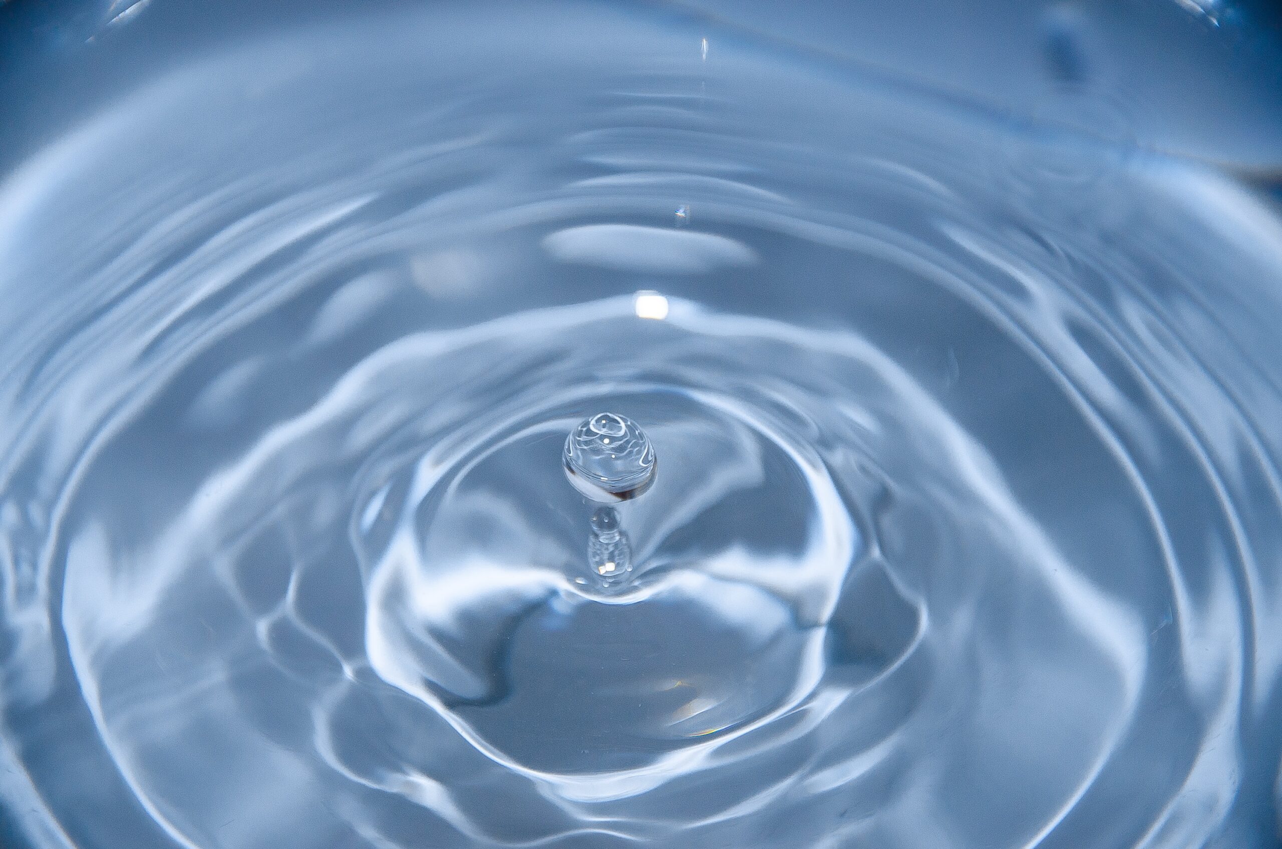 Close up of a droplet of water dropping into a big body of water