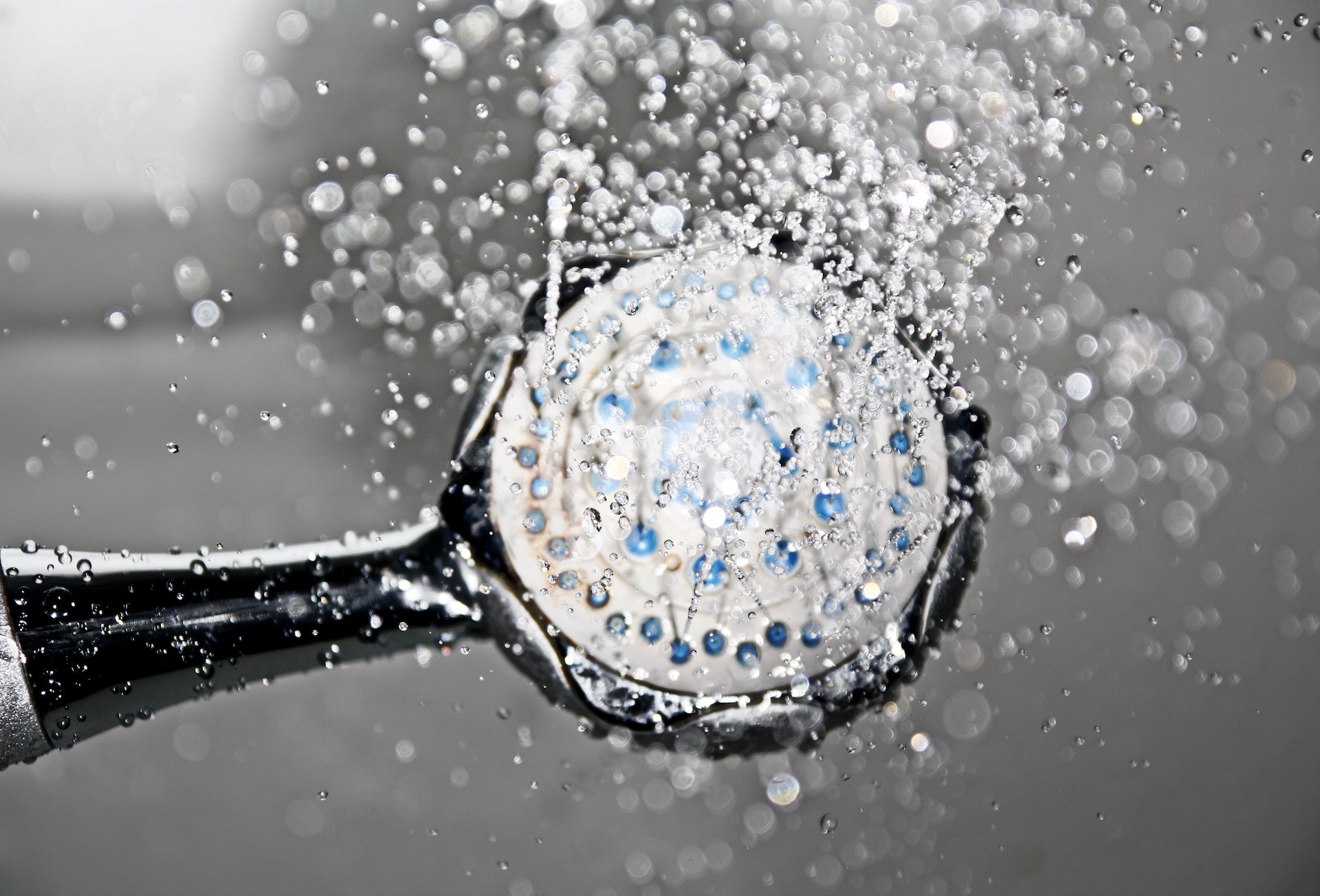 Shower head with droplets of water coming out of it