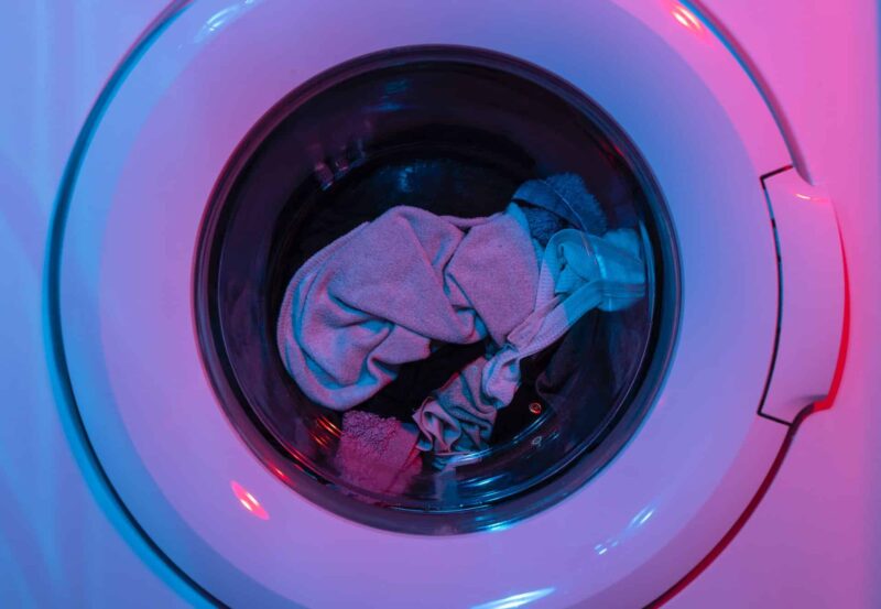 A washing machine filled with laundry, doing fewer laundry loads is an easy way to save energy at home