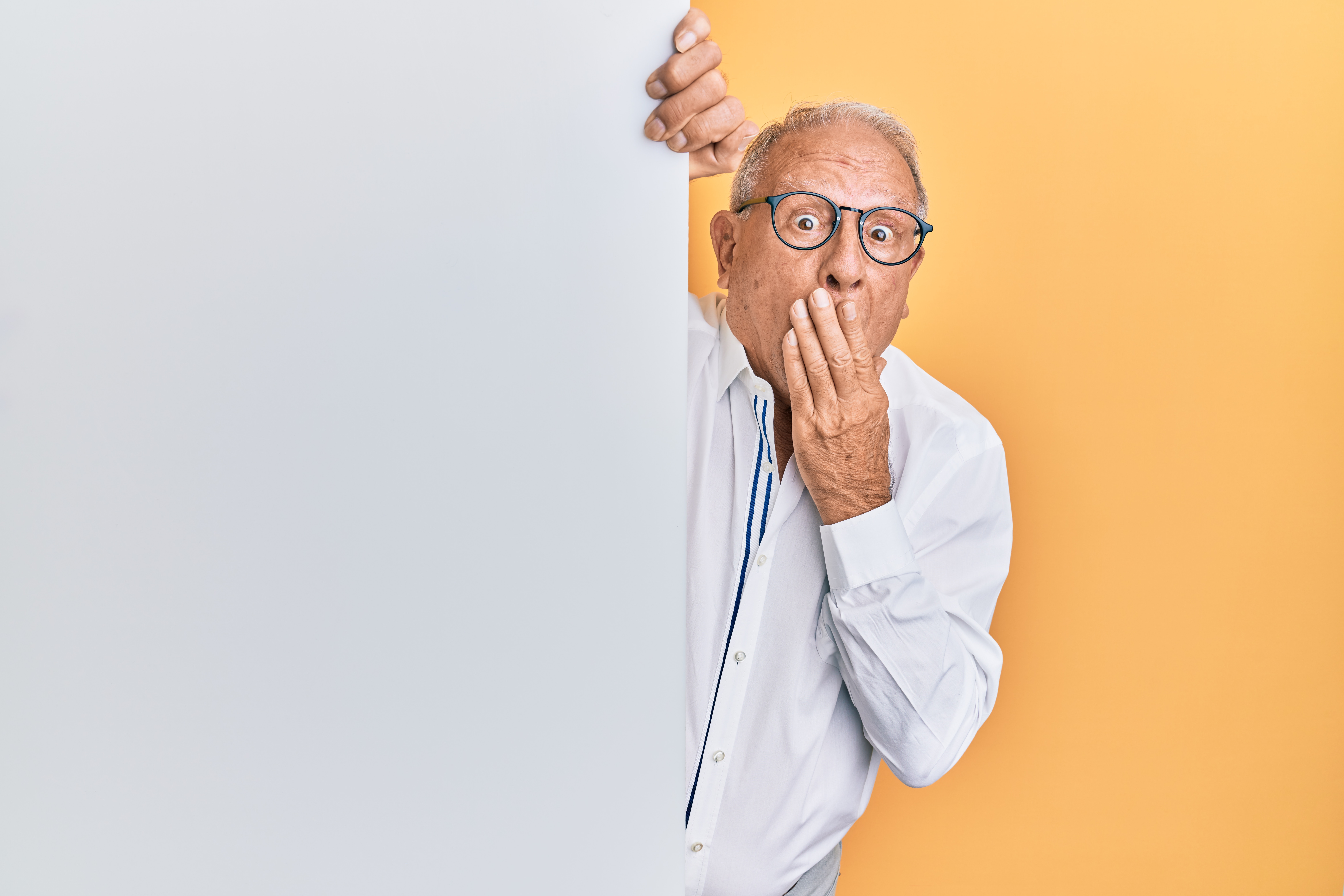 old man in a shirt looking very surprised over yellow background