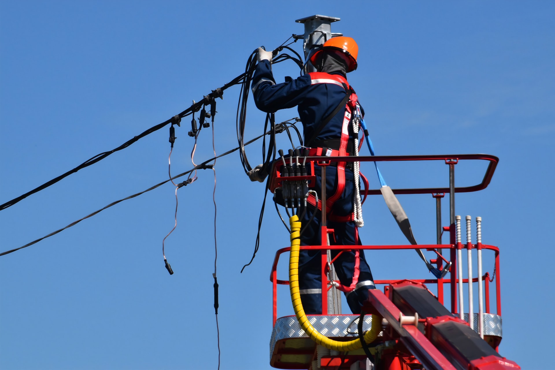 A worker adjusts overhead power cables that supply energy around the UK