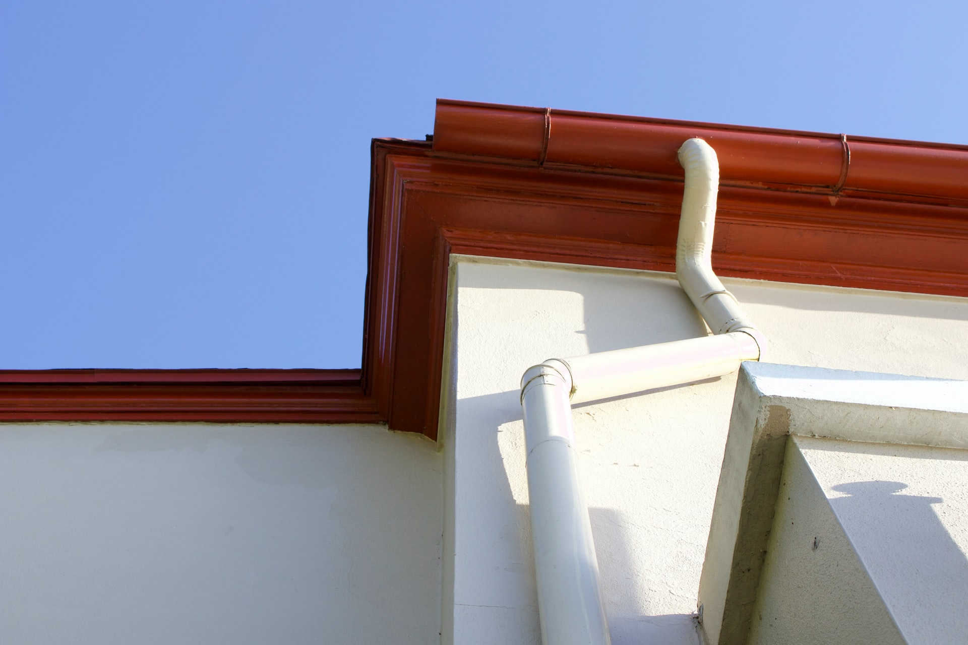 Gutters and drainpipe framed against the sky