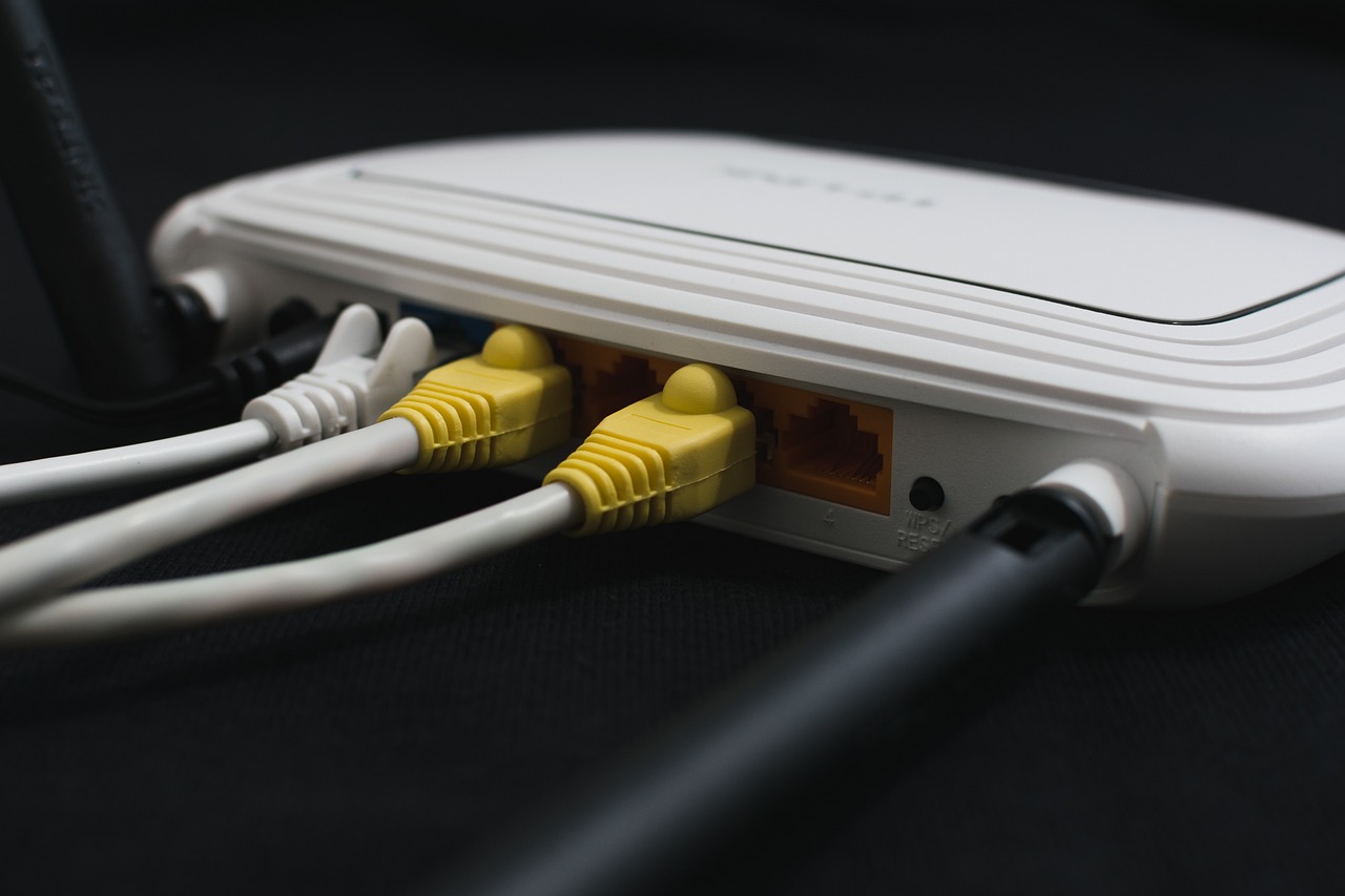 A wi-fi router on a black background, ethernet cables are attached to provide wired broadband