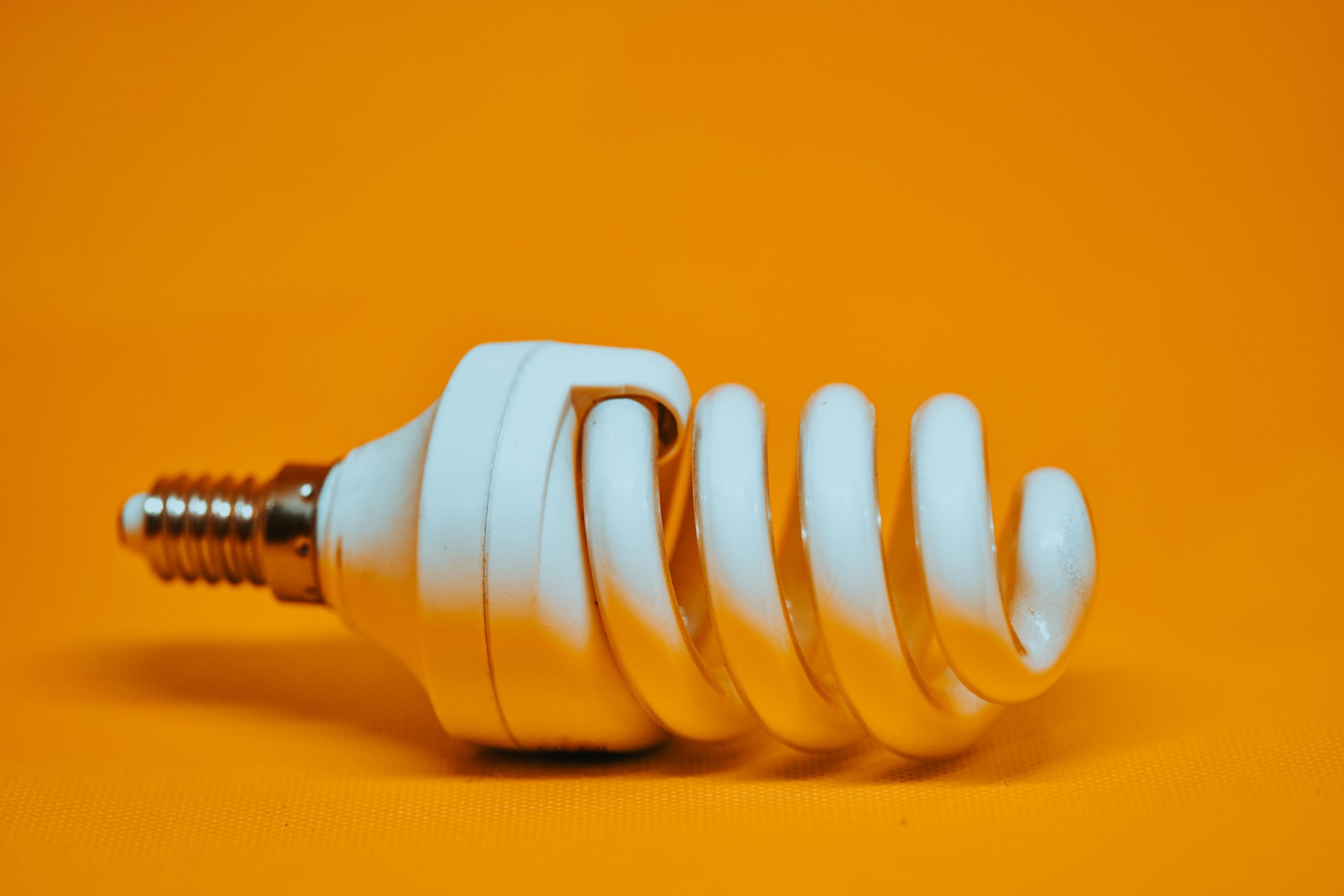 An energy efficient lightbulb against a yellow background