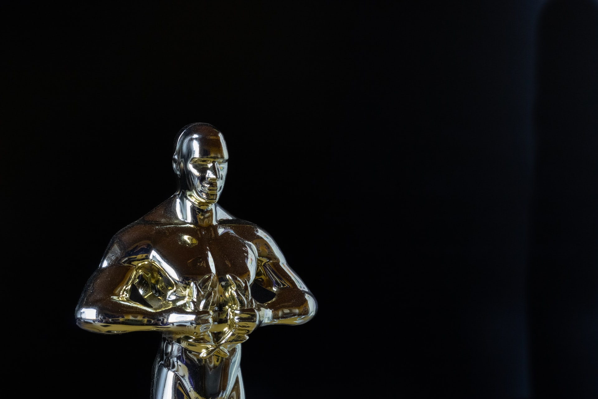 An Oscar 2023 statuette against a black background