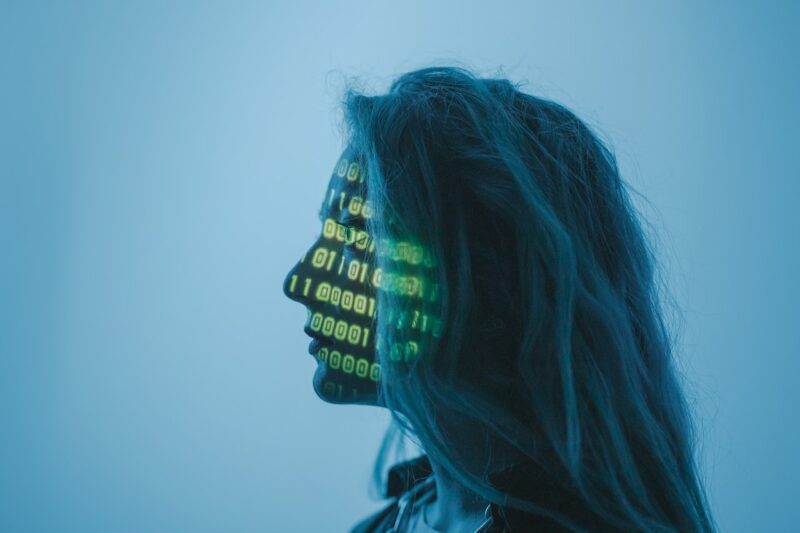 A woman with binary code projected on her face