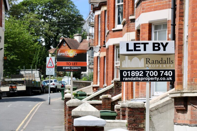 A street of houses with 'Let By' signs outside - rental demand means properties aren't staying on the market for long