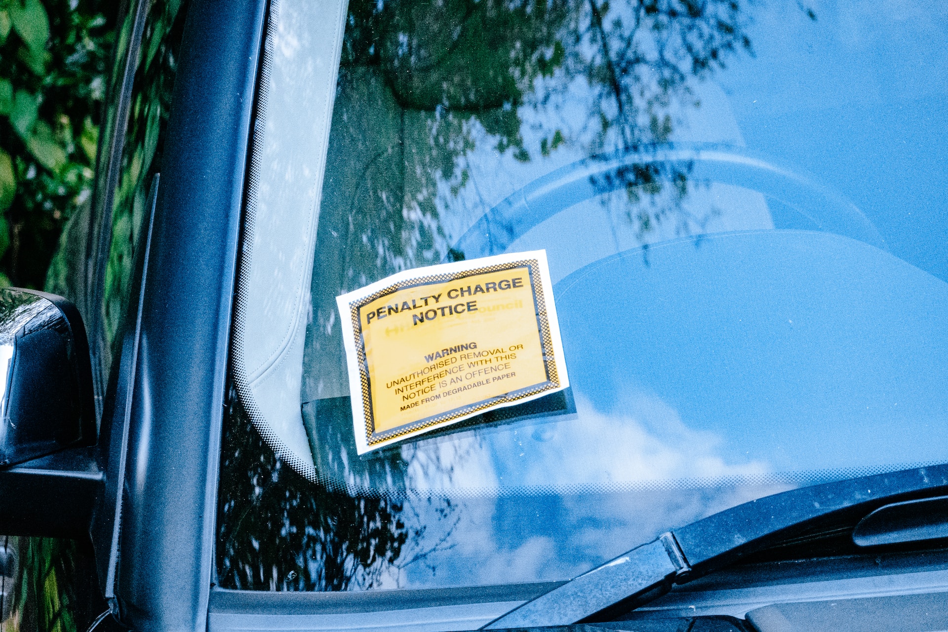 A penalty charge (parking fine) left on a car windshield