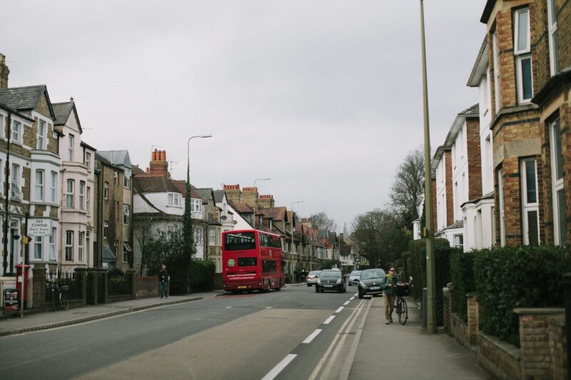 A road of houses in London with a red bus outside